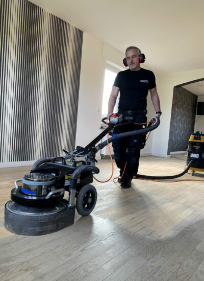 Parkett abschleifen Ewering Mitarbeiter mit Schleifmaschine