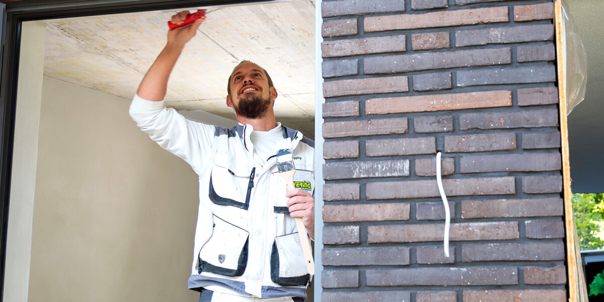 Ewering Mitarbeiter streichen Fenster Baustelle
