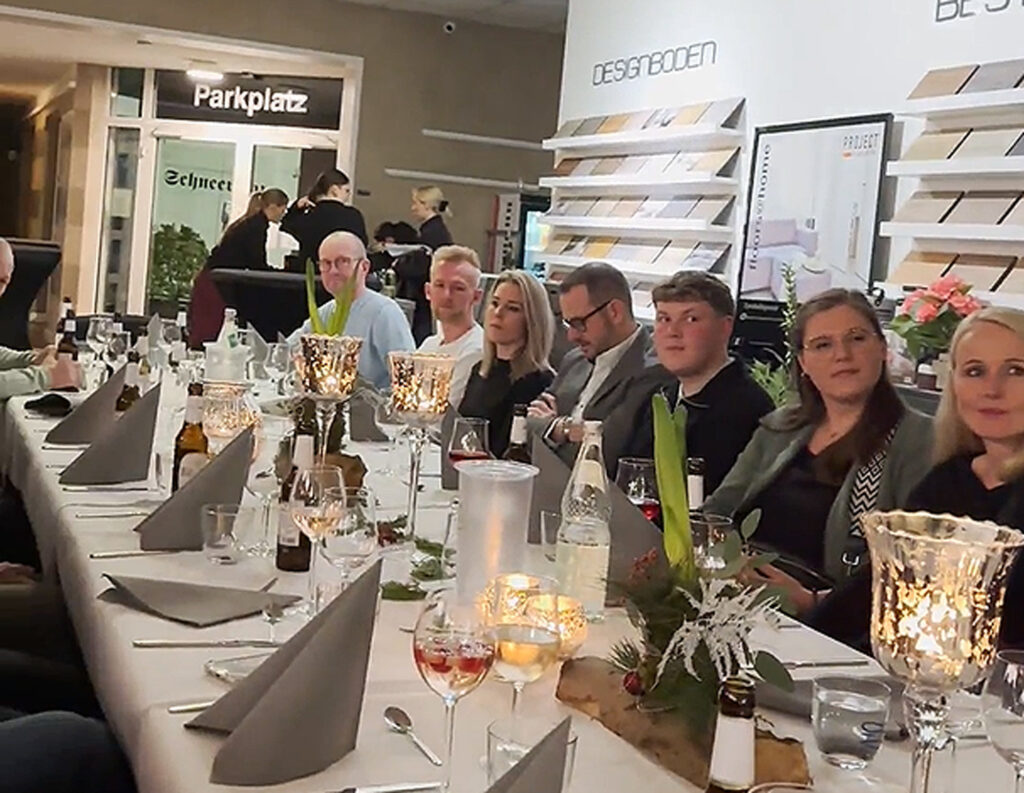 Weihnachtsfeier Ewering Reken Mitarbeiter Tischtafel Weihnachtsfeier von der Firma Ewering in unseren Fachmarkt in Reken. Mitarbeiter sitzen an einer langen und gedeckten Tischtafel.