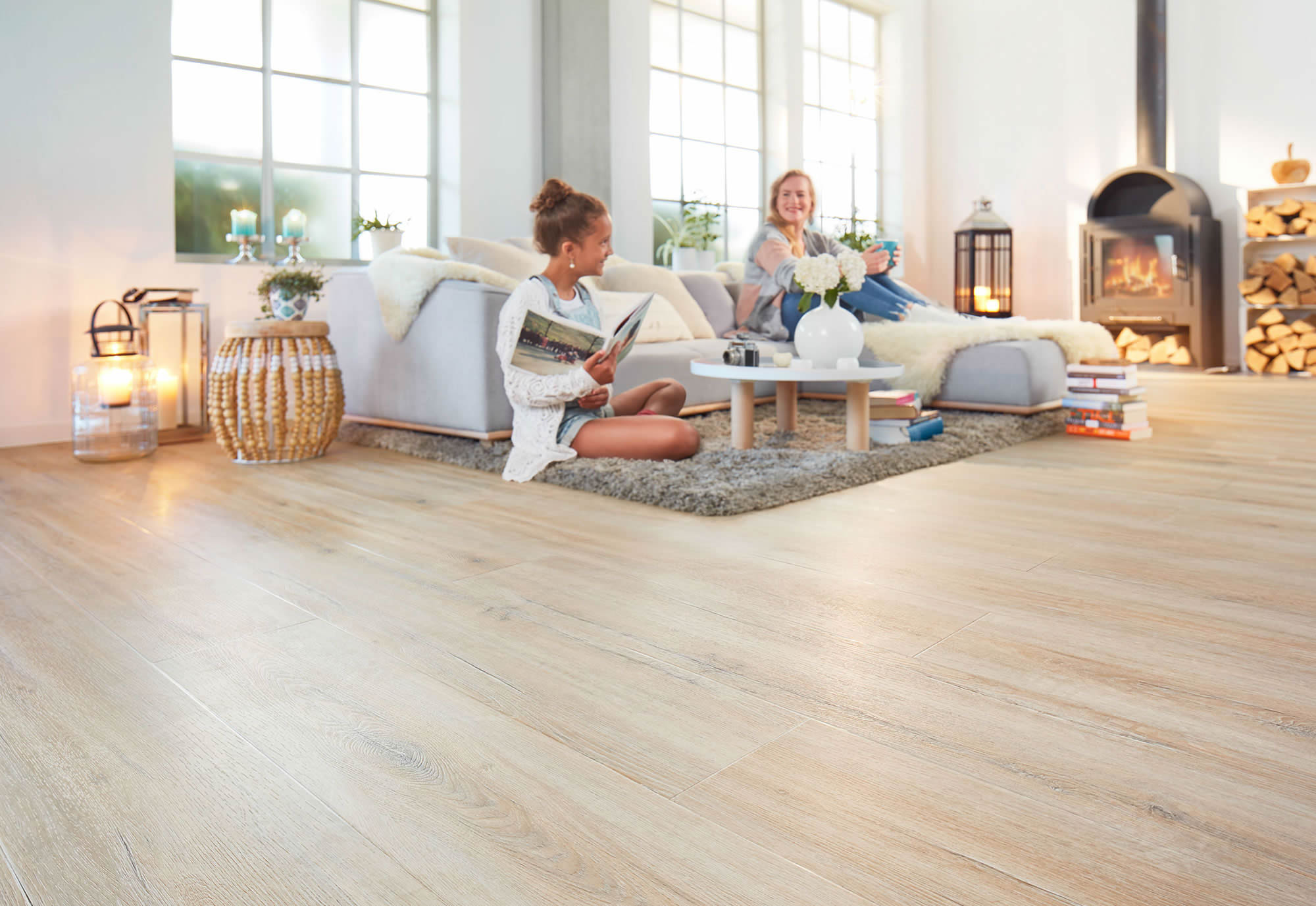 Modernes Wohnzimmer mit hell verlegtem Designboden in Holzoptik und großzügiger Wohnatmosphäre. Das Bild zeigt sauber ausgeführte Bodenbelagsarbeiten mit heller, wohnlicher und gepflegter Raumwirkung.