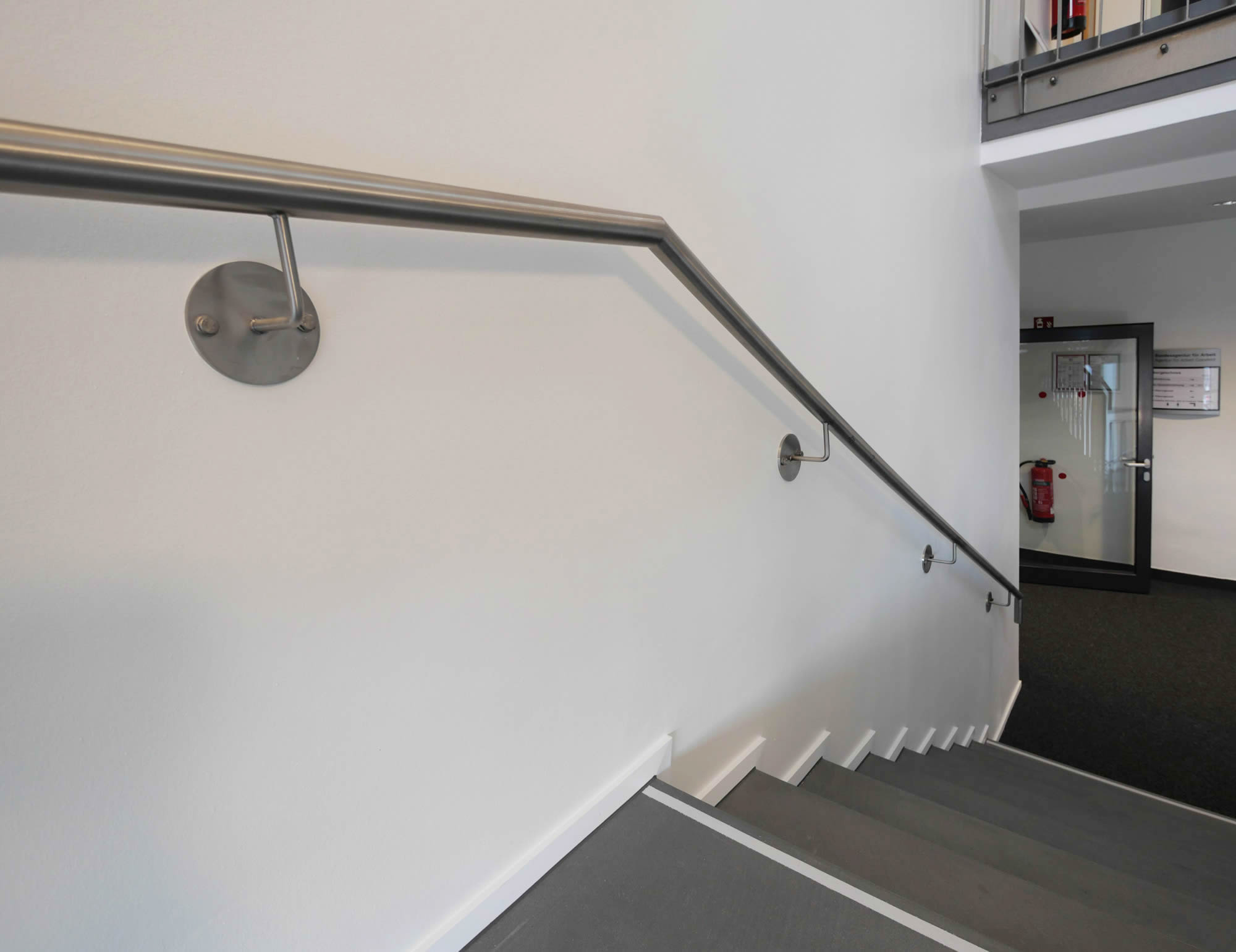 referenz_afa_coesfeld_treppenhaus_wandhandlauf_edelstahl_graue_stufen
