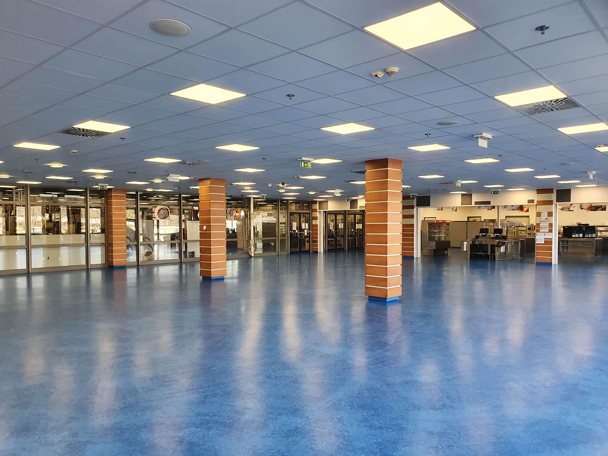 Große Kantinenfläche mit blau saniertem Boden nach abgeschlossener Bodensanierung.