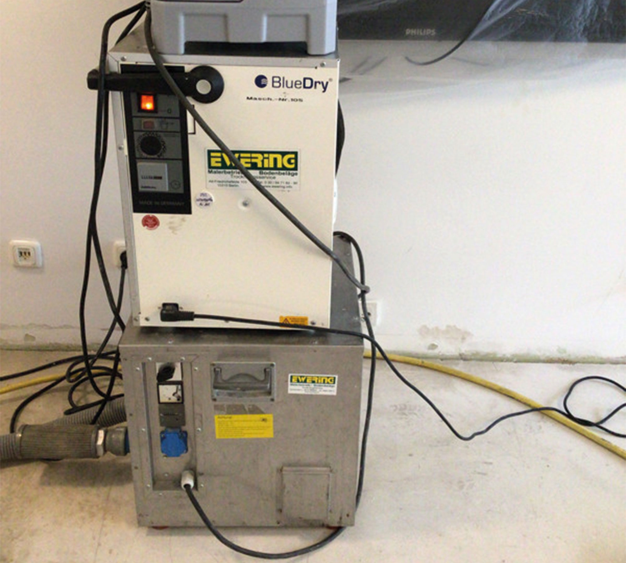 Mehrere Trocknungsgeräte von Ewering stehen in einem Innenraum zur technischen Trocknung nach einem Wasserschaden.