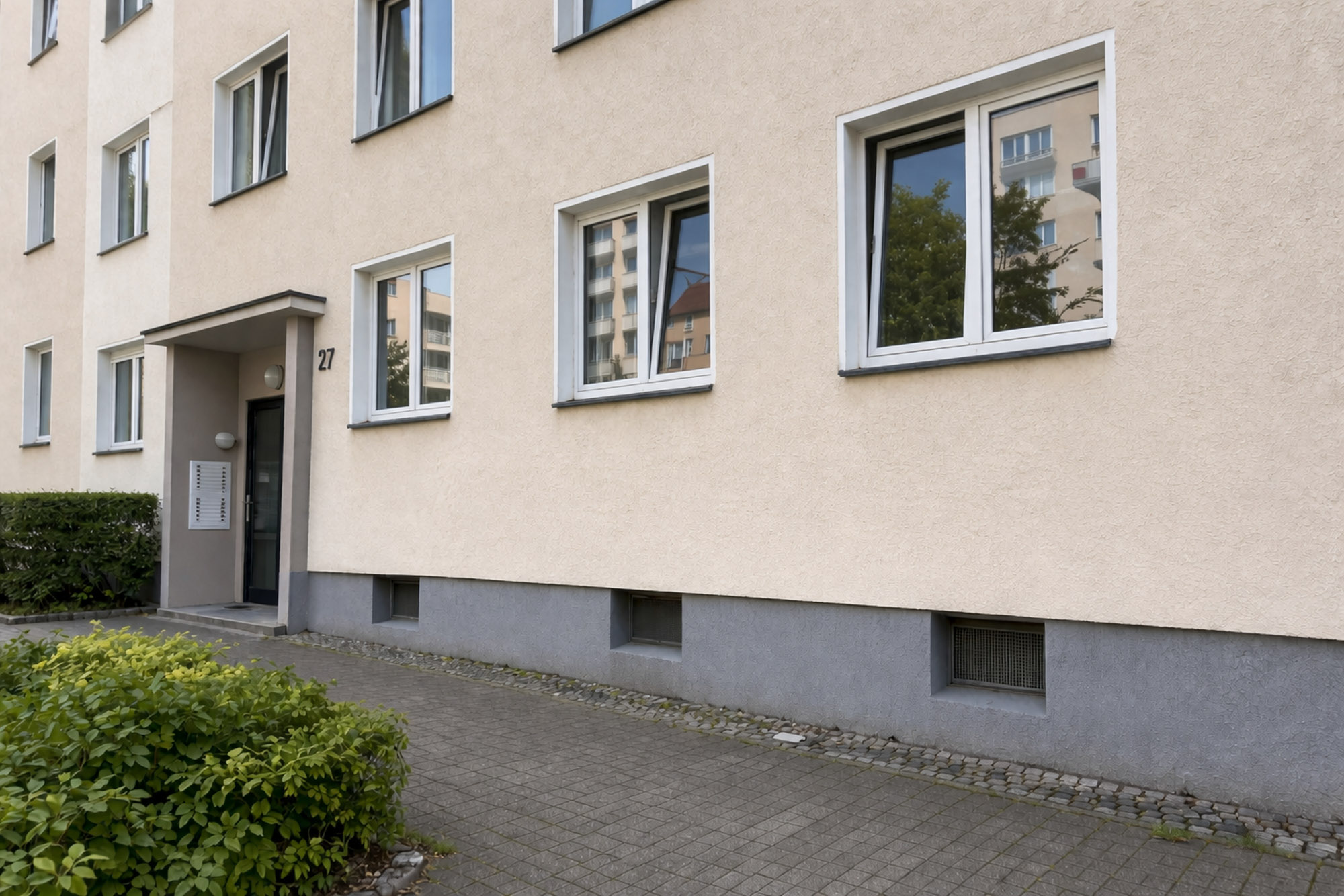 Saubere Fassade eines Mehrfamilienhauses nach erfolgreicher Graffitientfernung